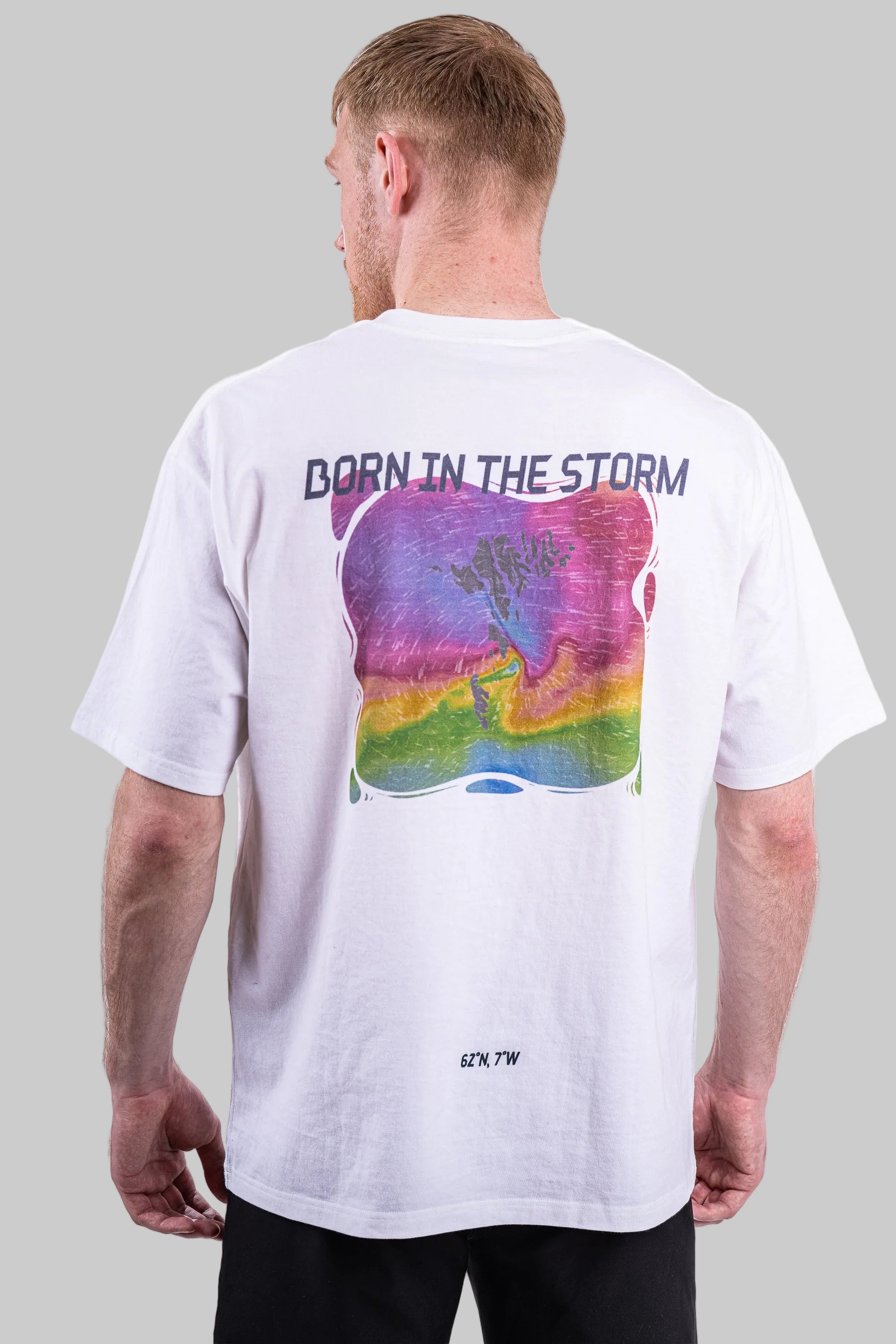 Person wearing a white t-shirt with a colorful graphic and text on the back.
