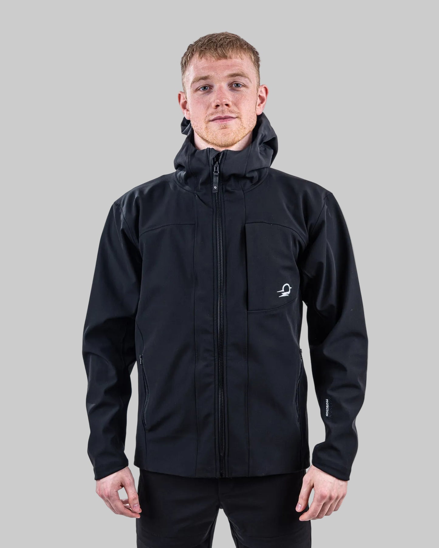 Person wearing a black jacket and pants on a white background